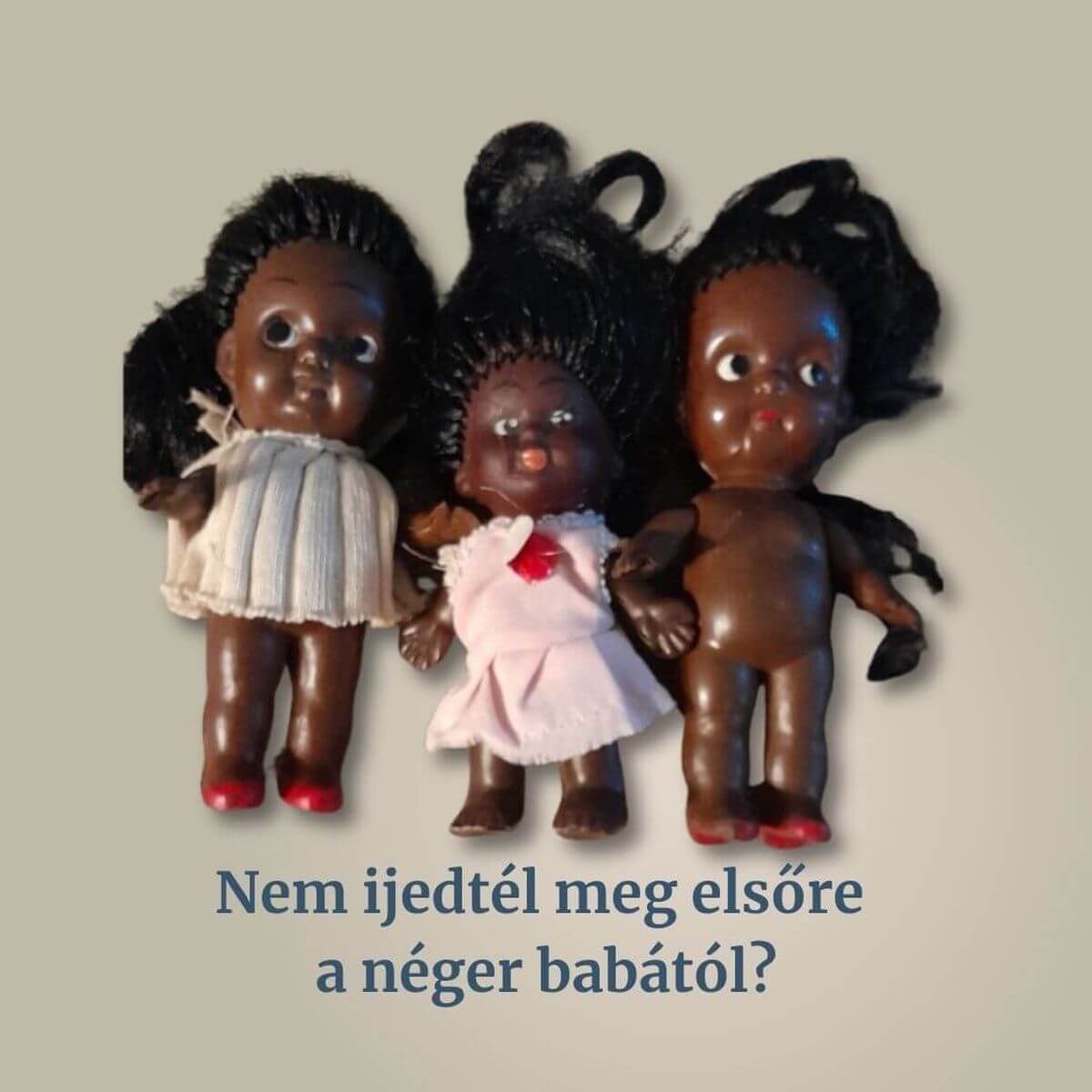 Három barna bőrű, fekete hajú, retro stílusú játékbaba, az egyik rózsaszín ruhában.